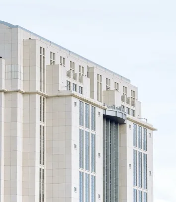 Upper floors of a modern cream stone office building with tall narrow windows